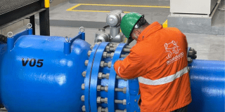 Imagen de un técnico de la empresa de Acueducto realizando mantenimiento en un tubo de alcantarillado.