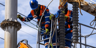 Imagen de un técnico de ENEL realizando mantenimiento en un poste de luz.