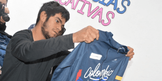 Imagen de un hombre sosteniendo y mirando una camiseta