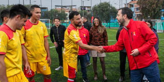 Imagen del alcalde Galán dándole la mano a un futbolista amateur en la cancha de Bilbao