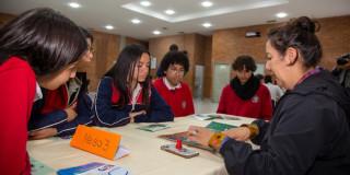 Foto que muestra estudiantes sentados en una mesa 