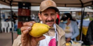 Un campesino mostrando una pera