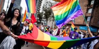 Foto integrantes de comunidades LGBTI con banderas en Bogotá durante una manifestación.