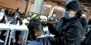 Imagen de una persona peluqueando a un habitante de calle