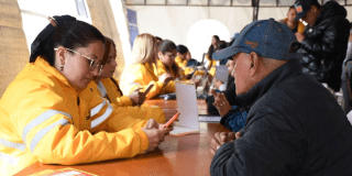 Imagen de una funcionaria atendiendo a un señor