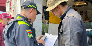 Foto de un policía sellando un establecimiento en Bogotá