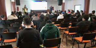 Foto que muestra personas sentadas en una sala 