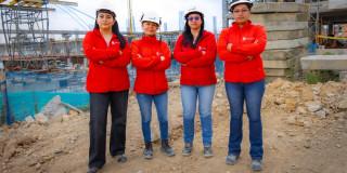 Cuatro mujeres con casco blanco sonriendo 