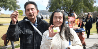 Imagen de dos personas mayores mostrando la Tarjeta Tu Llave