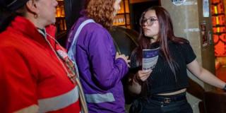 Funcionaria de la SDMujer hablando con una transeúnte.