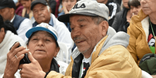Imagen de dos personas mayores mirando un celular