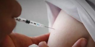 Persona colocando una vacuna en un brazo 