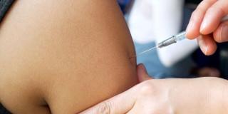 Foto que muestra una persona colocando una vacuna en un brazo