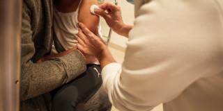 Foto que muestra una enfermera colocando una vacuna