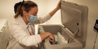 Foto que muestra una enfermera revisando unos recipientes