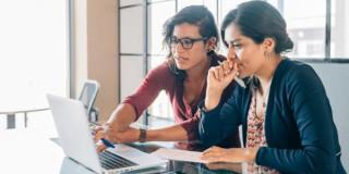 Foto de dos mujeres accediendo a cursos virtuales en Bogotá.