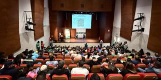 Foto que muestra personas reunidad en un auditorio 