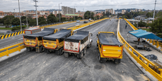 Imagen de tres volquetas en el puente de la 153