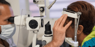 Imagen de un médico revisando los ojos de una paciente