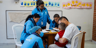 Foto de un grupo de funcionarios con un ciudadano y un niño