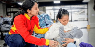 Imagen de una funcionaria con una madre que carga a su bebé