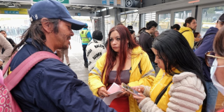 Imagen de una funcionaria hablando con un habitante de calle en una estación de TransMilenio