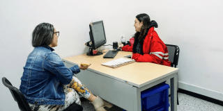 Imagen de una funcionaria atendiendo a una mujer 