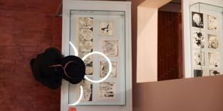 Imagen de persona observando exposición de Cómic en blanco y negro