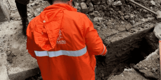 Imagen de un técnico de la empresa de Acueducto realizando mantenimiento en un tubo de alcantarillado.