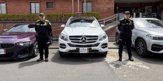 Imagen de dos policías junto a los vehículos recuperados