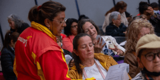 Imagen de una funcionaria pública hablando con una señora de la comunidad