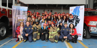 Imagen de niños y niñas posando para una foto en la estación de Bomberos