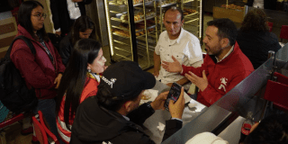 Imagen del alcalde Galán hablando con comerciantes dentro de una panadería