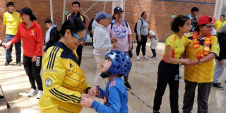 Imagen de una señora jugando con un niño con discapacidad