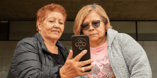 Imagen de dos mujeres adultas mayores viendo un celular