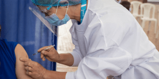 Imagen de una enfermera vacunando a un hombre.