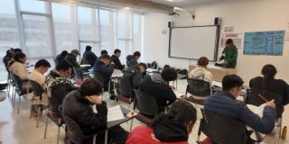 Foto que muestra estudiantes sentados en un salón 