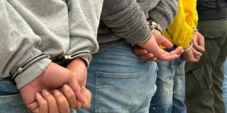Personas esposadas por la Policía 