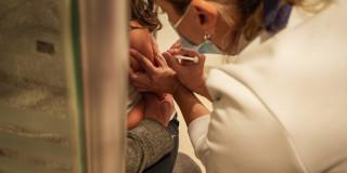 Foto que muestra una enfermera colocando una vacuna