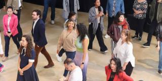 Foto de hombres y mujeres en una sala caminando.