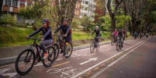 Foto de bogotanos y bogotanas usando bicicleta y circulando por una ciclorruta en Bogotá.