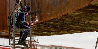 Foto de obreros realizando trabajos en un puente vehicular en Bogotá.