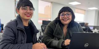 Dos mujeres sonriendo y estudiando