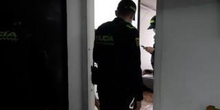 Foto de doss policías haciendo procesos de investigación en una vivienda en Bogotá.