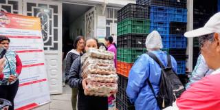 Imagen de varias personas cargando alimentos