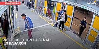 Imagen de cámara de seguridad en la que se ve a hombre intentando subirse a un bus de TransMilenio con una craga no permitida.