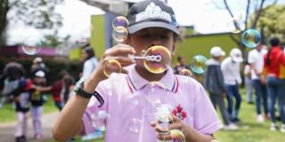 Niño jugando con burbujas en parque de Bogotá