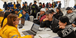Imagen de una funcionaria atendiendo a un vendedor y a una vendedora ambulante