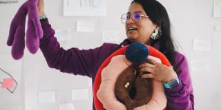 Mujer enseñando anatomía de los órganos sexuales femeninos.