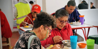Imagen de dos señoras comiendo un almuerzo en comedor comunitario